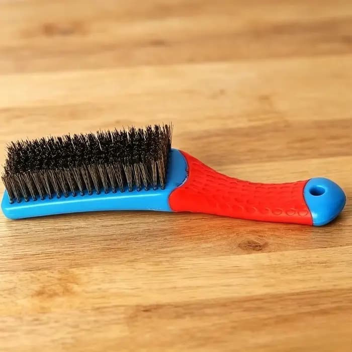 Brosse métallique en acier inoxydable robuste avec poignée en plastique confortable, idéale pour éli
